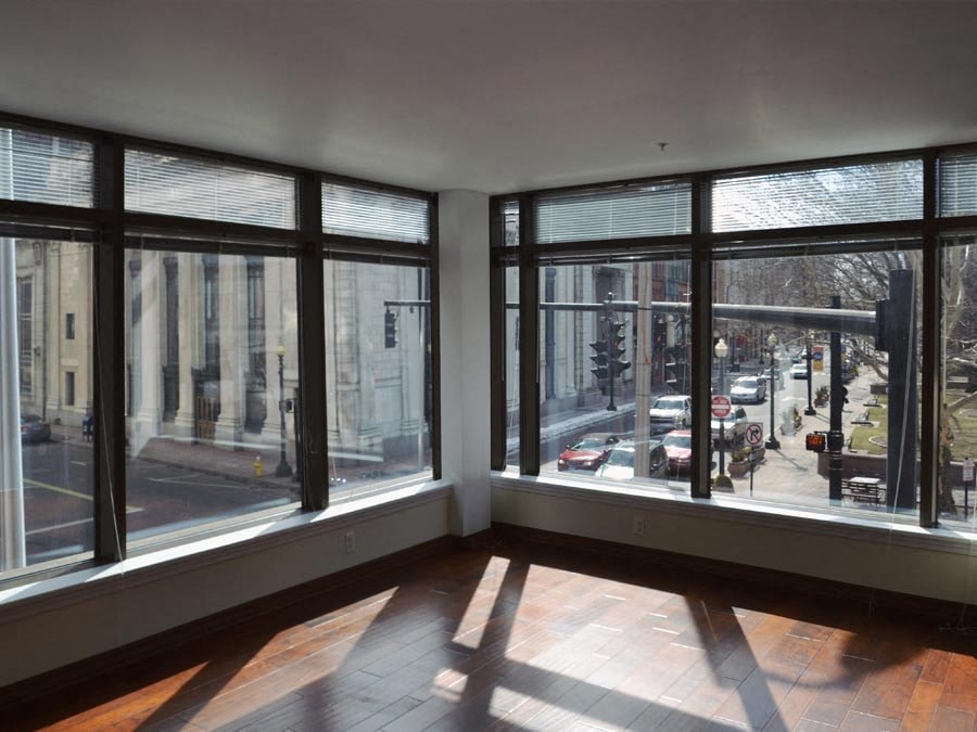 an empty living room with large windows overlooking a city street