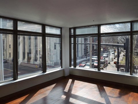 an empty living room with large windows overlooking a city street