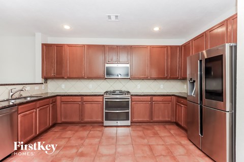 a kitchen with wooden cabinets and stainless steel appliances