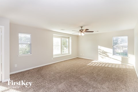 a living room with carpet and a ceiling fan