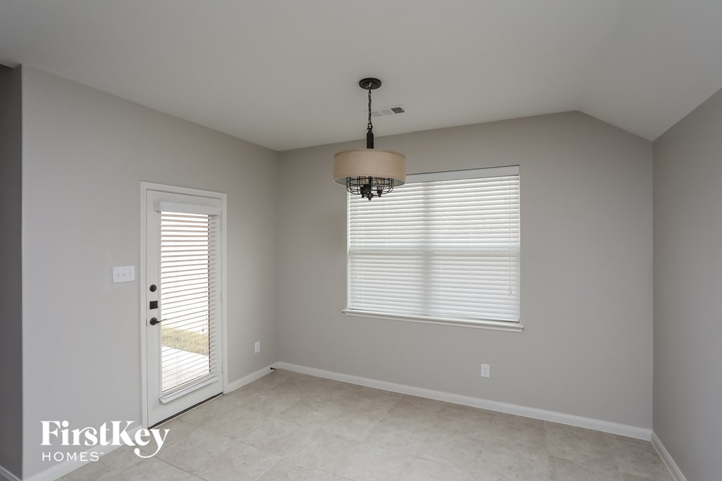 an empty room with a door and a window and a light fixture