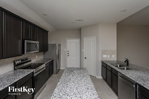 a kitchen with granite counter tops and stainless steel appliances