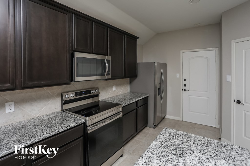 a kitchen with granite counter tops and stainless steel appliances