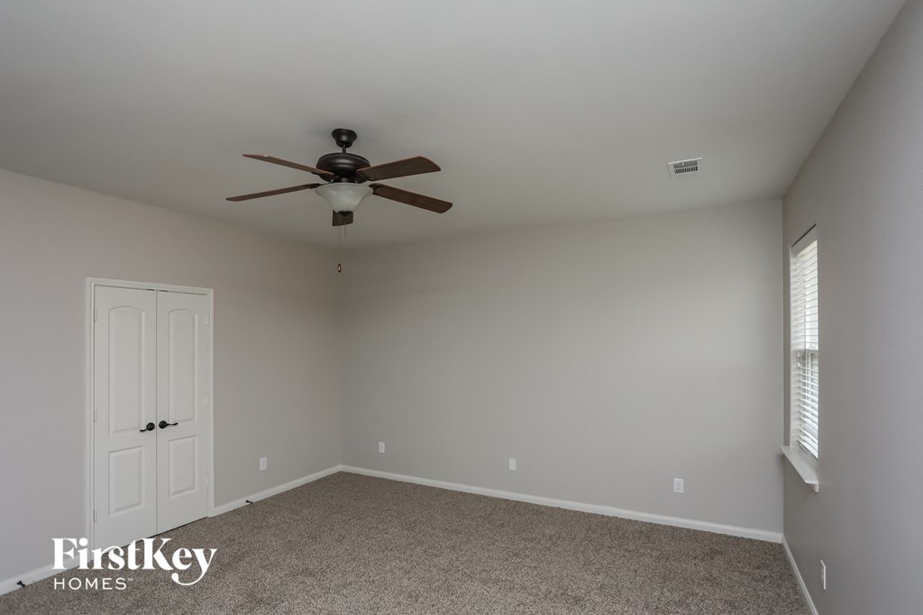a bedroom with a ceiling fan and a white door