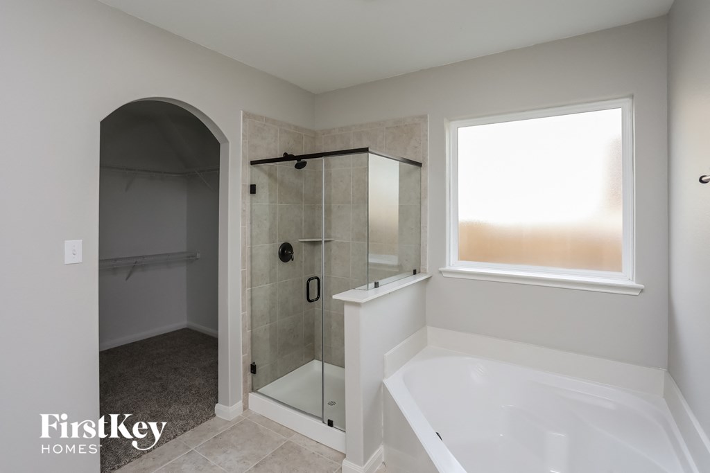 a bathroom with a large tub and a shower and a window