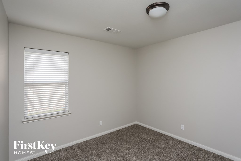 an empty room with a window and a carpet