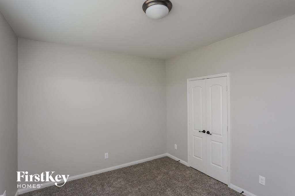 a bedroom with white walls and a white door