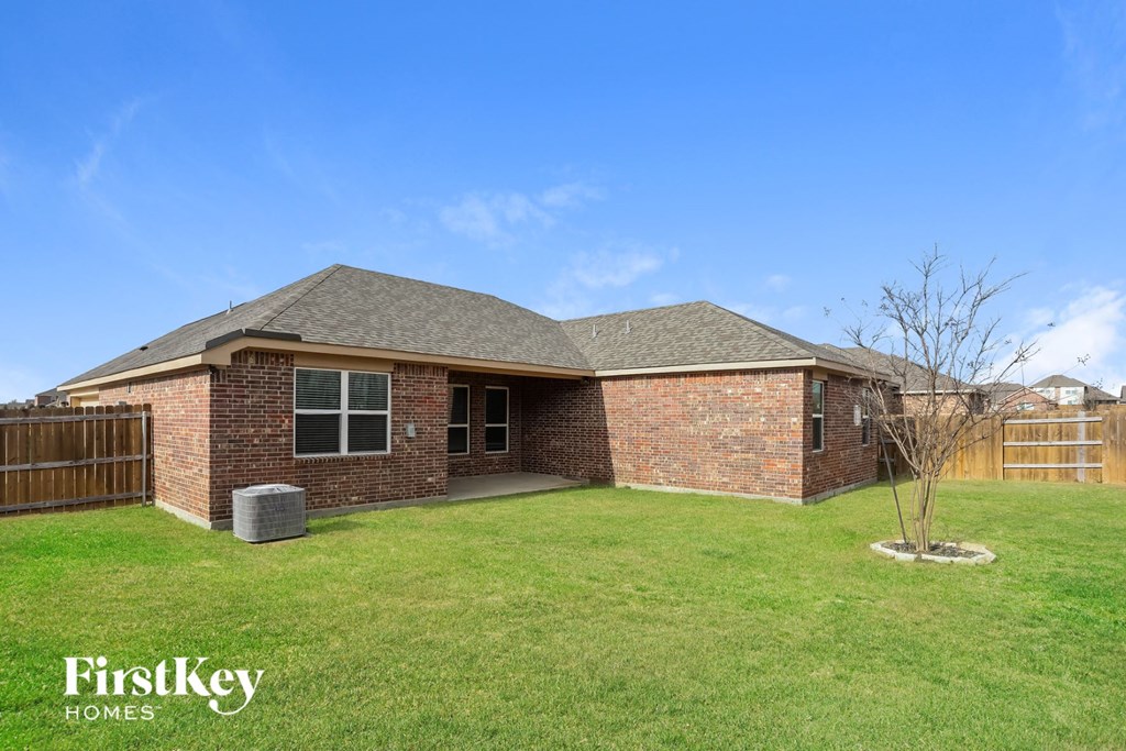 a home with a grassy yard and a brick house