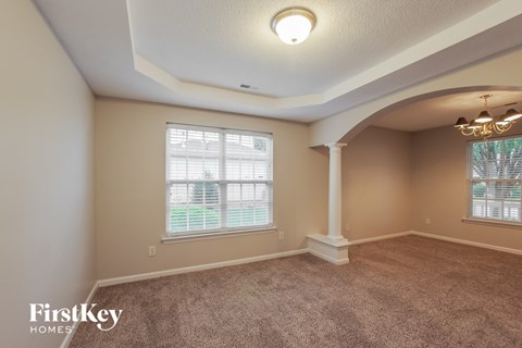 a living room with a carpeted floor and a large window