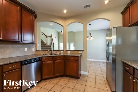 A kitchen with wooden cabinets and a stainless steel refrigerator.