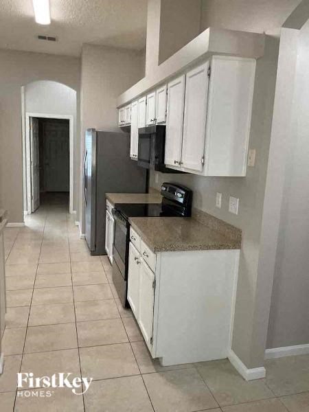 A kitchen with white cabinets and a granite countertop.