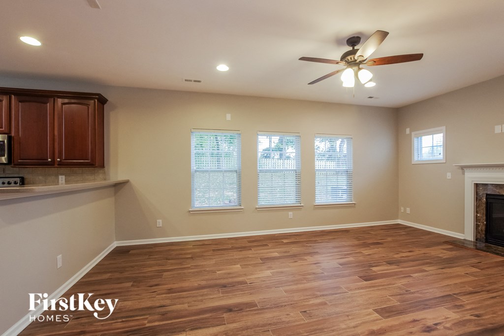 a living room with a wood floor and a ceiling fan
