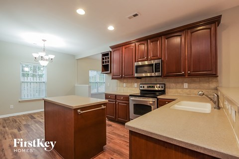 an updated kitchen with wood cabinets and white counter tops and appliances