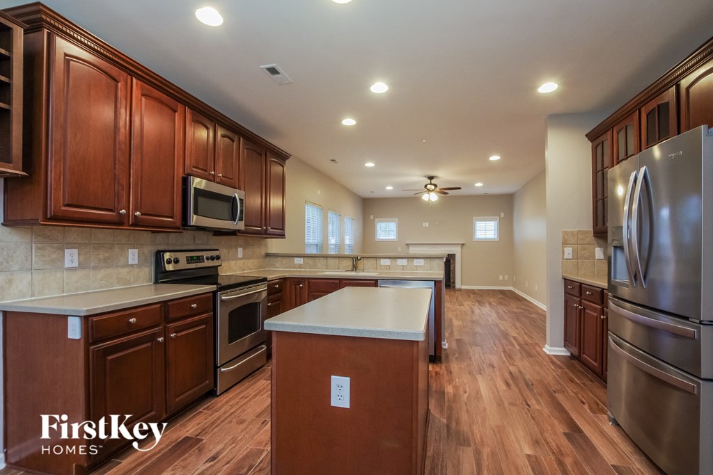 a large kitchen with stainless steel appliances and wood flooring
