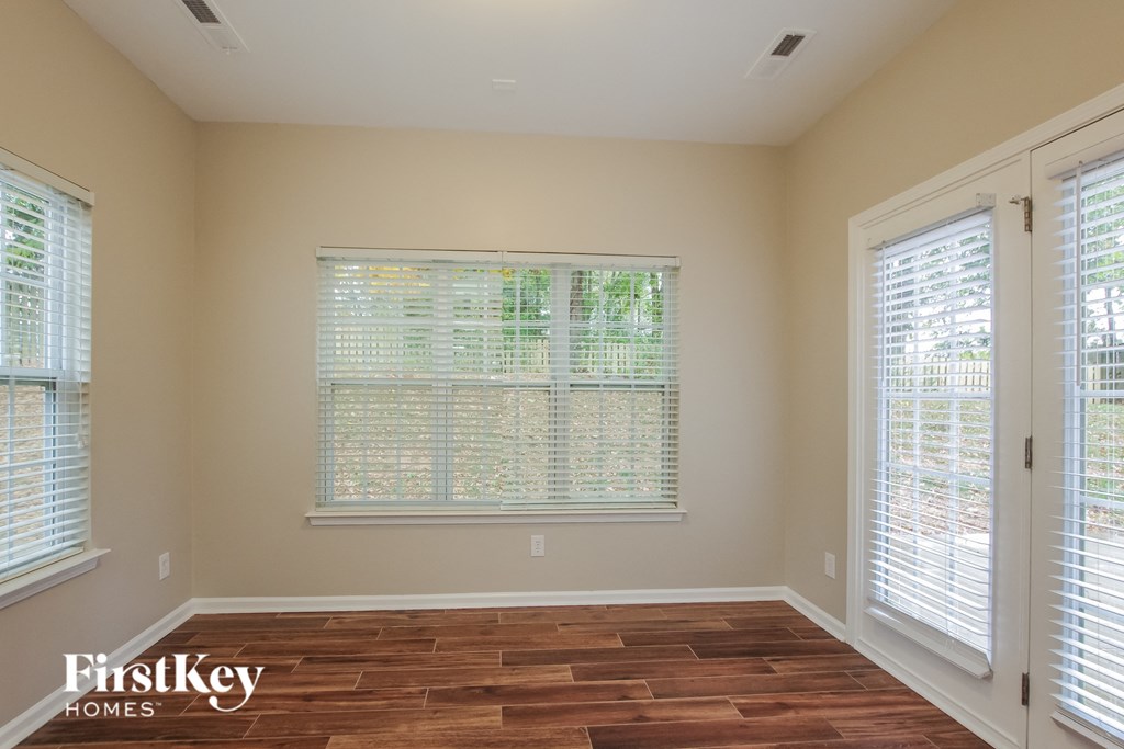 a living room with a large window and wooden floors