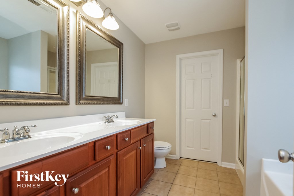 a bathroom with two sinks and a toilet and a mirror