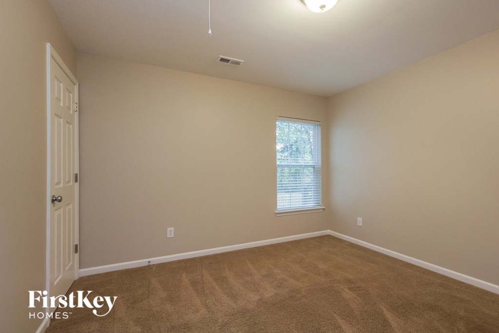 a bedroom with a carpeted floor and a window