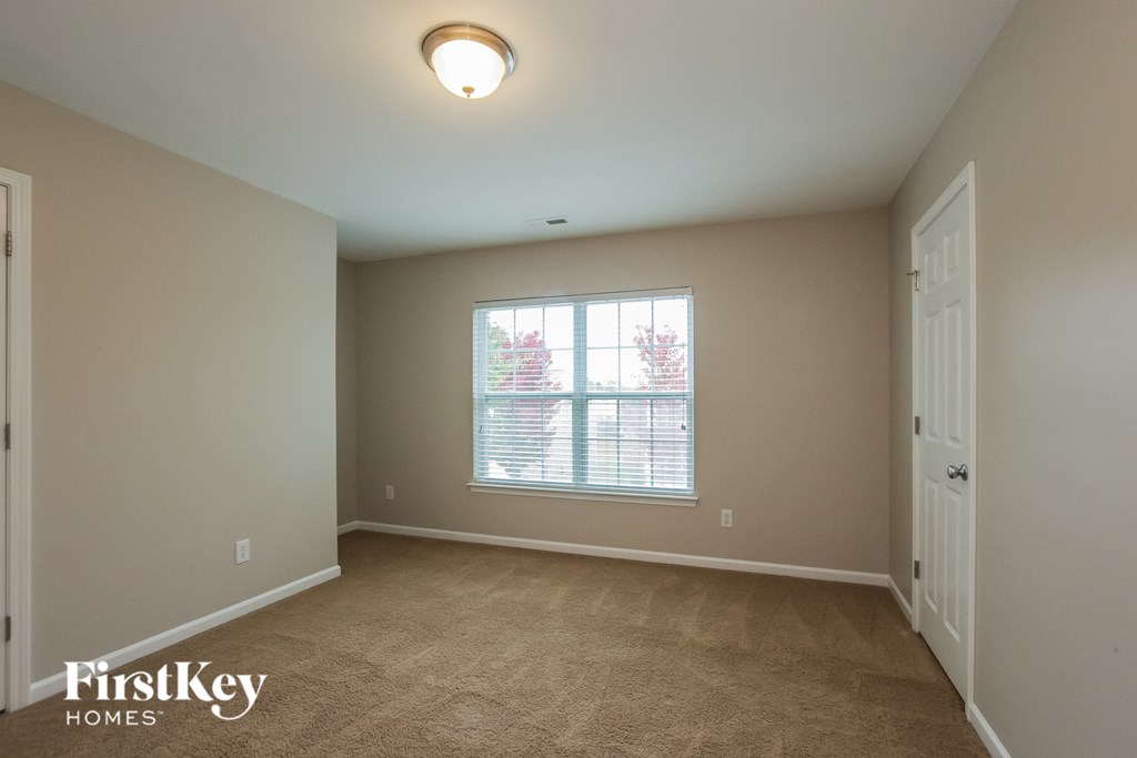 an empty living room with a window and a door