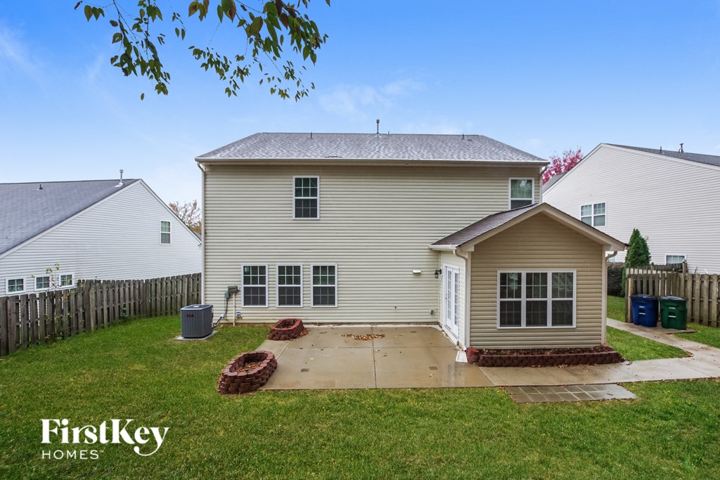 a backyard with a white house and a yard with a patio