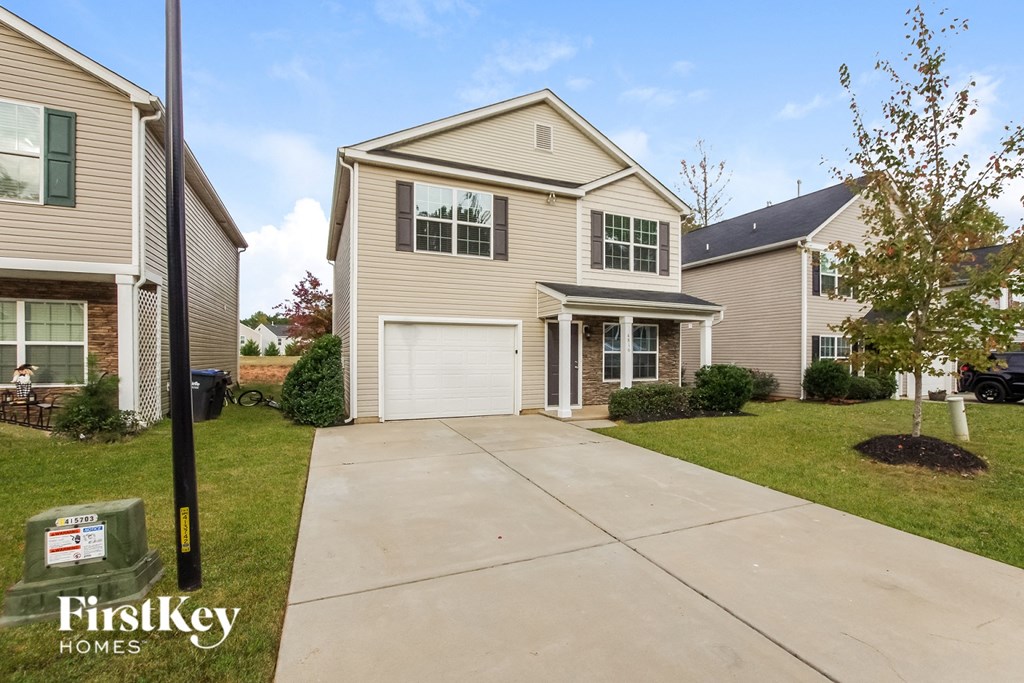 A house with a driveway in front of it and a sign that says FirstKey Homes.