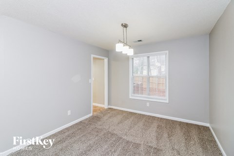 a spacious living room with carpet and a window