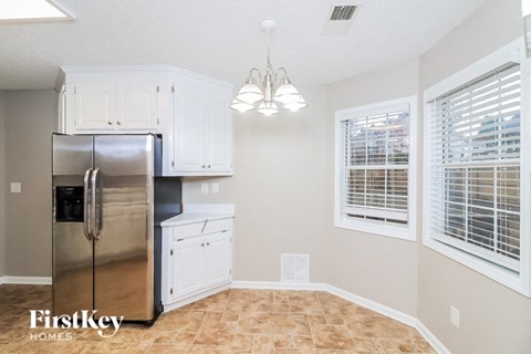 a kitchen with white cabinets and a stainless steel refrigerator
