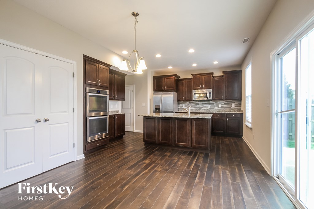 A modern kitchen with wooden floors and a large island.