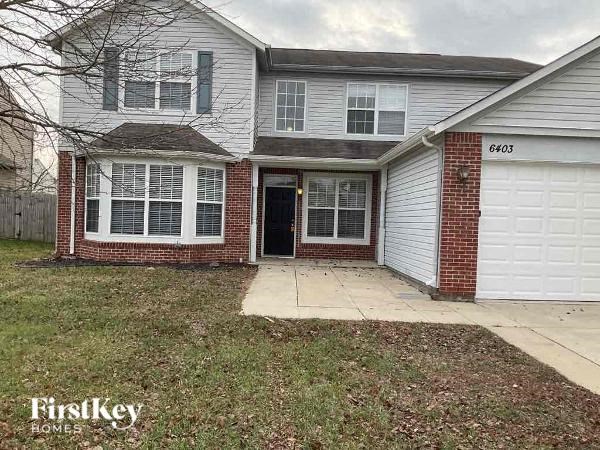 A two-story house with a garage and a driveway.