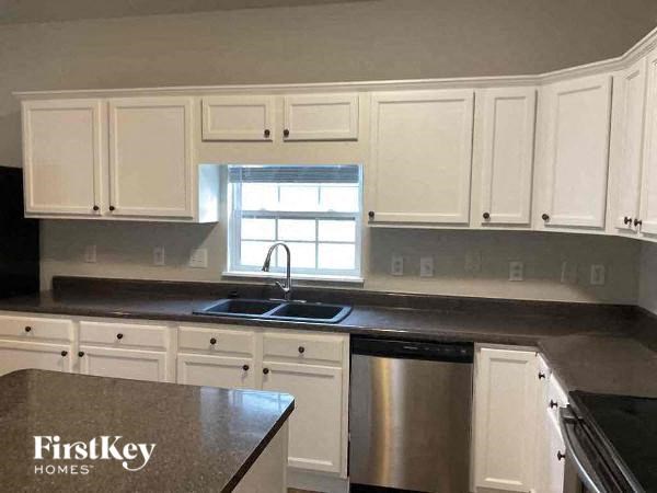 A kitchen with white cabinets and a stainless steel dishwasher.