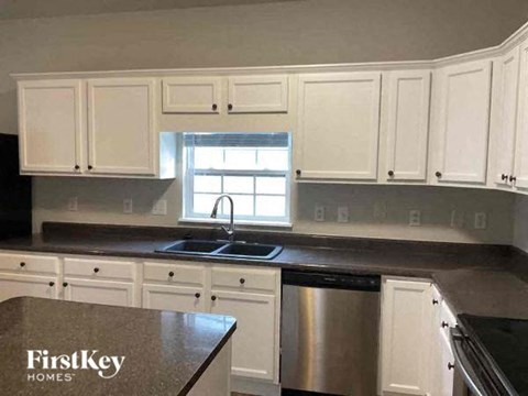 A kitchen with white cabinets and a stainless steel dishwasher.