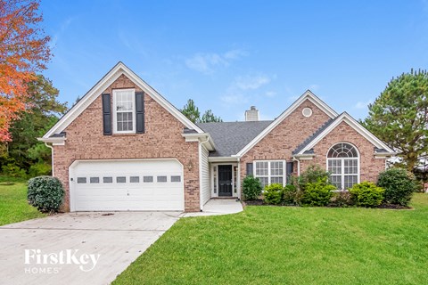 a brick house with a lawn and a white garage door