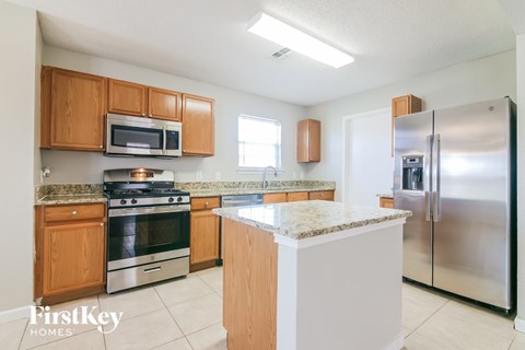A kitchen with wooden cabinets and a granite countertop.