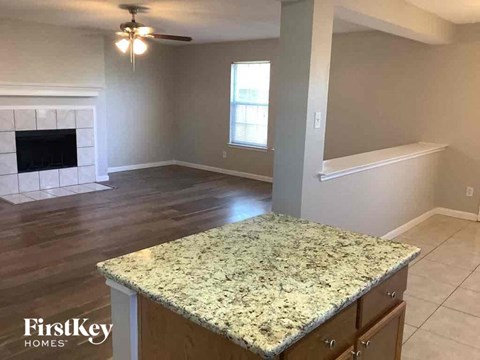 A kitchen with a granite countertop and a fireplace.