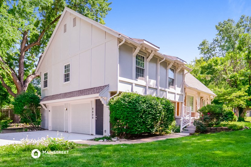 a white house with a garage and a lawn