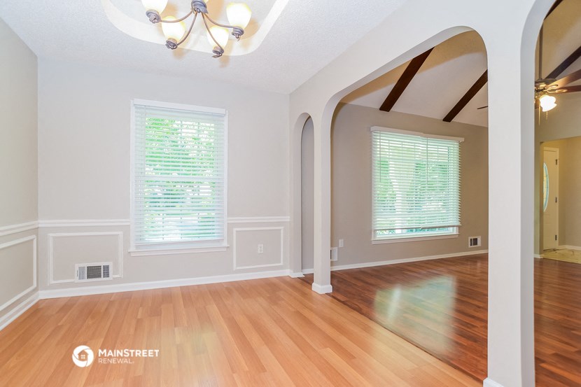 the living room with hardwood floors and a large archway
