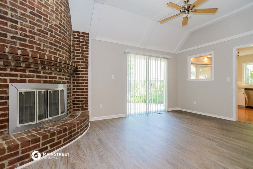 the living room with fireplace and sliding glass doors to the patio