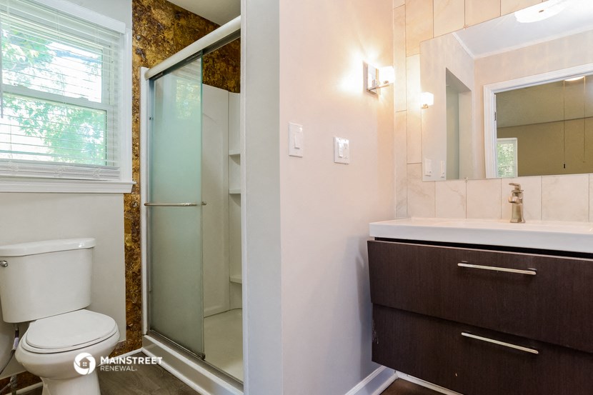 a bathroom with a toilet and a shower and a sink