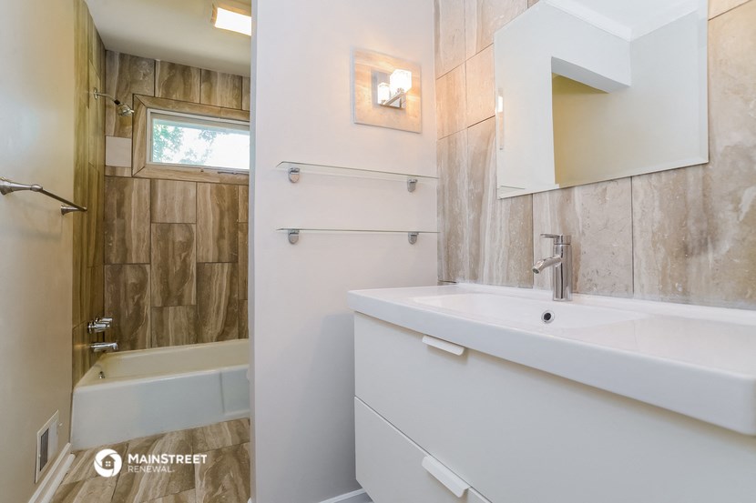 a bathroom with a sink and a shower and a mirror