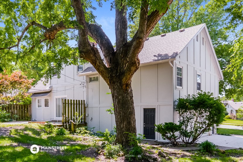 a white house with a tree in front of it