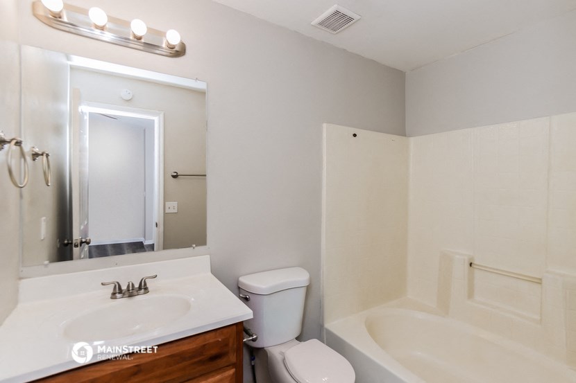 a bathroom with a sink toilet and a tub and a mirror