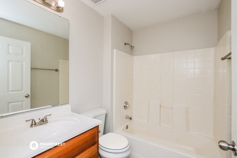 a bathroom with a white tub and a sink and a toilet