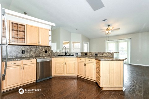 a large kitchen with wooden cabinets and granite counter tops