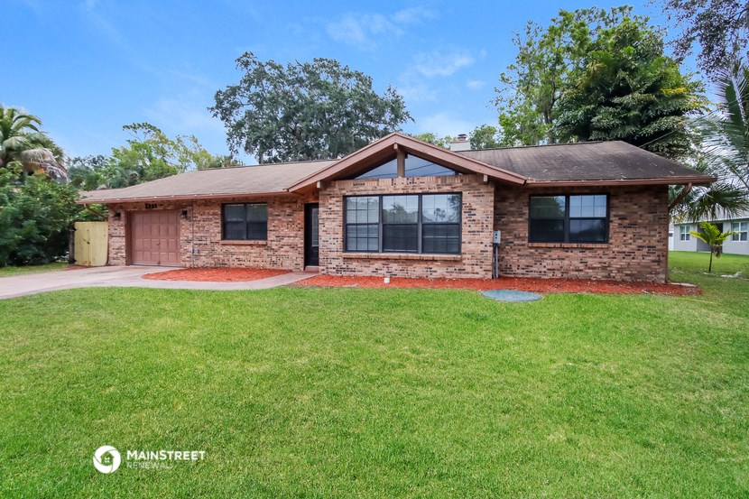 a small brick house with a lawn in front of it