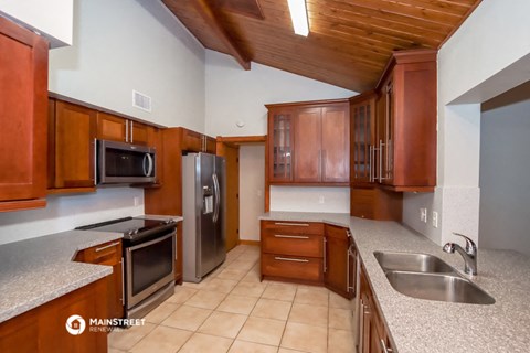 the kitchen has granite counter tops and stainless steel appliances