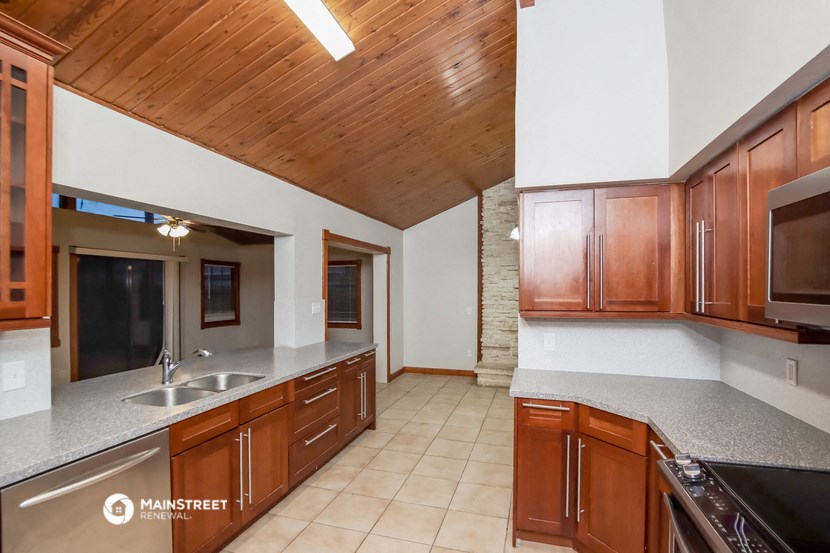 a kitchen with granite counter tops and wooden cabinets