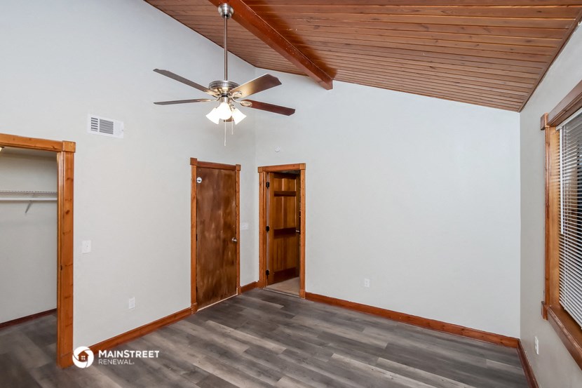 the living room of an empty house with a ceiling fan