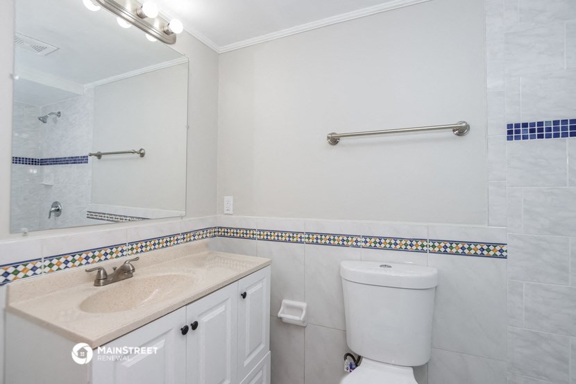 a bathroom with a toilet and a sink and a mirror