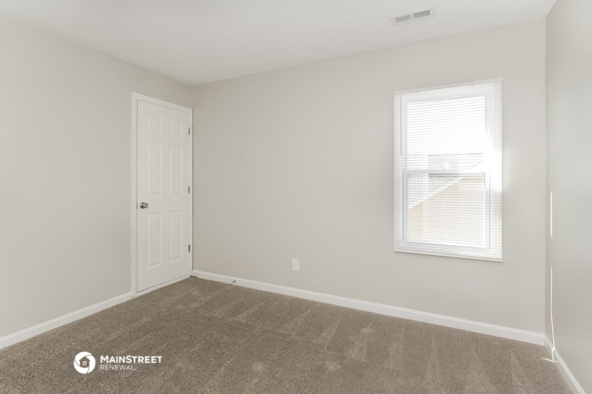 a room with carpet and a door and a window