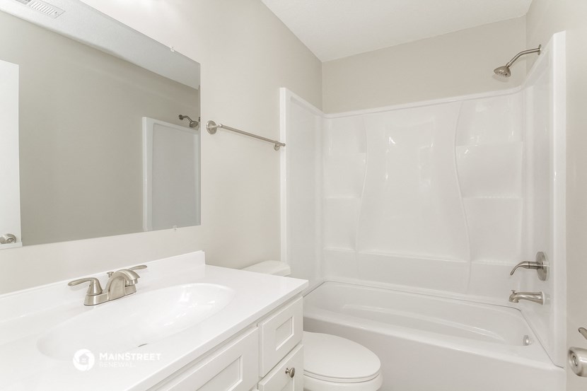 a bathroom with a sink and a tub and a mirror