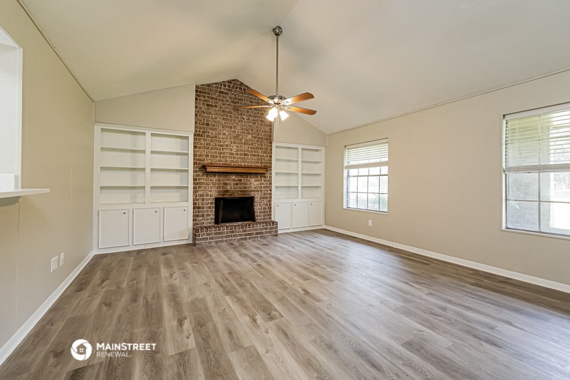 the living room with fireplace and wood flooring
